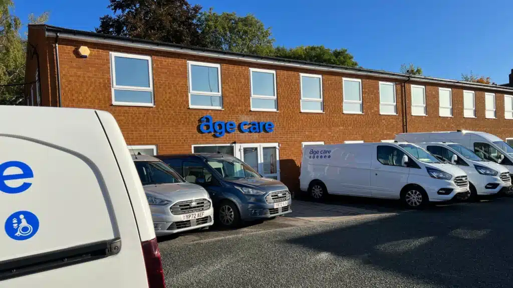 A photo of the exterior of the Age Care Maintenance with several company vans and cars parked outside.